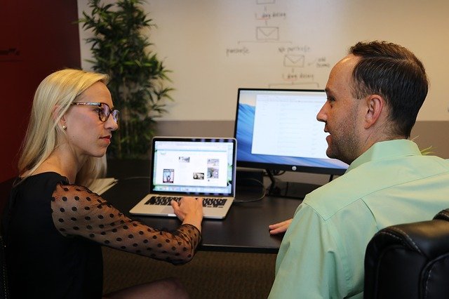 man and woman in office discussing work