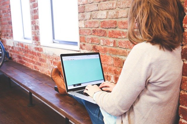 woman working with laptop on bench