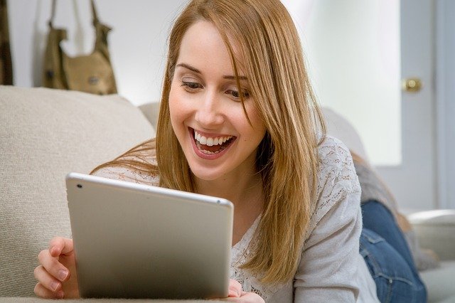 woman using tablet and smiling
