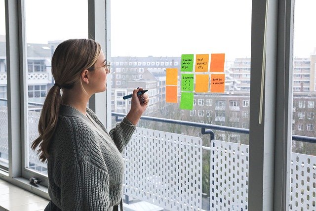 woman placing post-its on glass window